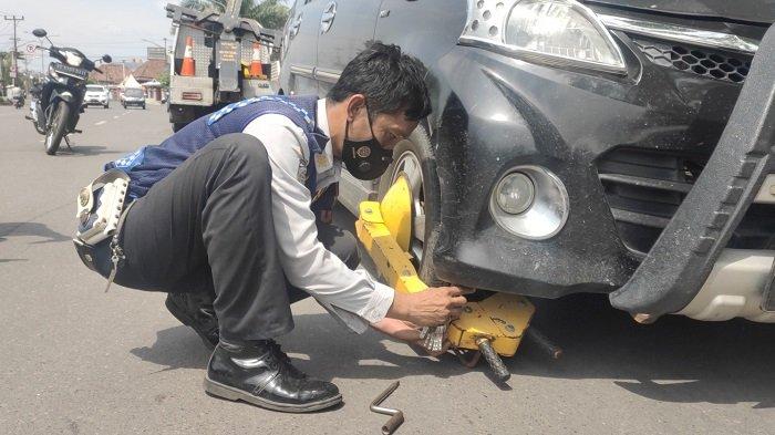 Petugas Dishub melakukan tidakan tegas kendaraan roda empat yang parkir di jalan Ahmad Yani tepatnya didepan kantor Cacatan Sipil Muara Enim, Rabu (23/6/2021). 